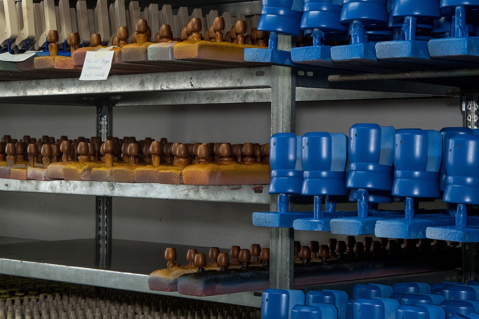 Metallregal mit mehreren Reihen von blauen und braunen Holzteilen auf Haltern